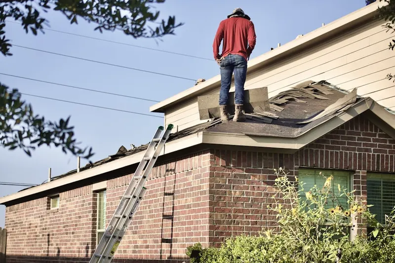 Professional roofer working on a residential roof in Norwood